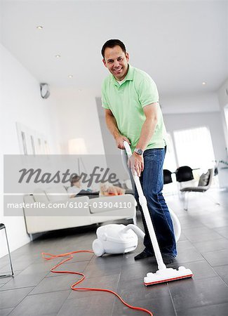 A man vacuuming a floor, Sweden.