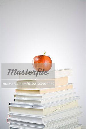 An apple on a pile of books.