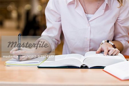 Ein weiblicher Student Studium in einer Bibliothek, Schweden.