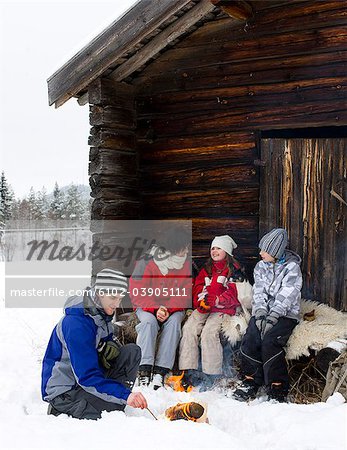 Family taking a break by a mountain hut, Sweden.