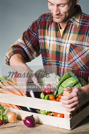 Man holding a box of vegetables.