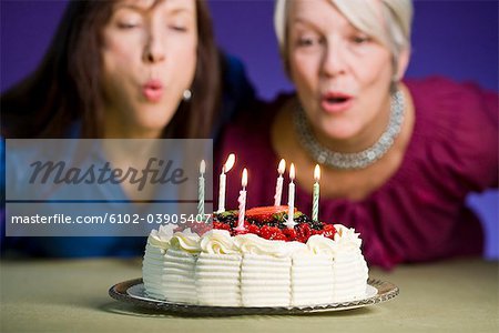 Two women with a birthday cake.