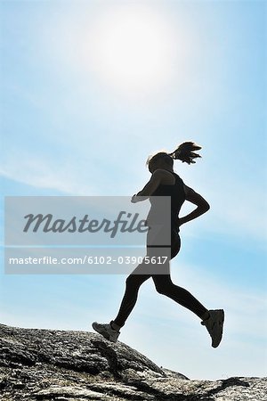 Jeune femme en cours d'exécution sur un ciel bleu, Suède.