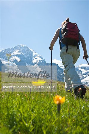 Backview de randonnée femme en utilisant des bâtons de marche, Oberland bernois, Suisse