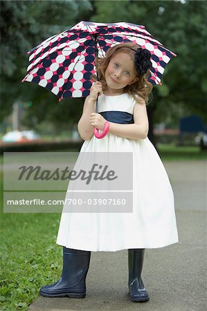 Portrait de fleur fille portant des bottes en caoutchouc et tenir parapluie