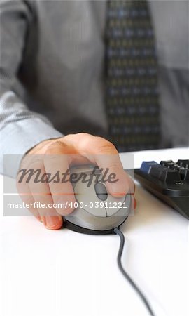 Closeup of man's hands with computer mouse and keyboard
