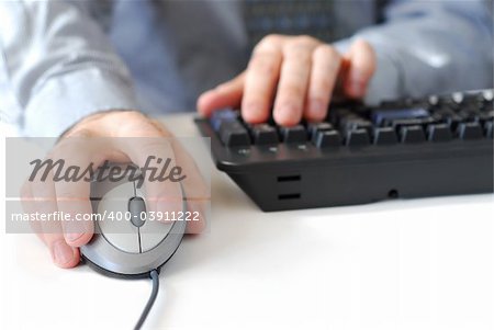 Closeup of man's hands with computer mouse and keyboard