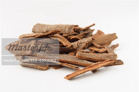 Cinnamon sticks chopped, isolated on white. Shallow depth of field, focused on the centre of the pile.