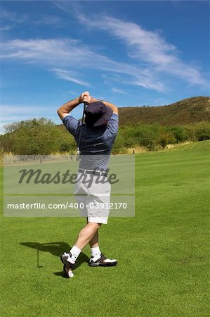 Golfer hitting the ball from the fairway.
