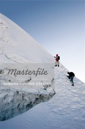 Two climbers about to summit Island Peak in Nepal. The peak is very close to Everest and Lhotse. This picture was taken in in the middle of October at 6:45am.