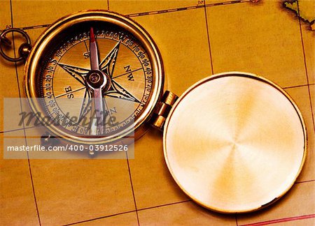 Old style brass compass on antique map