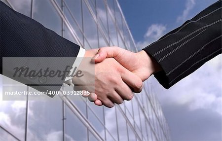 business hand shake and a office in background,