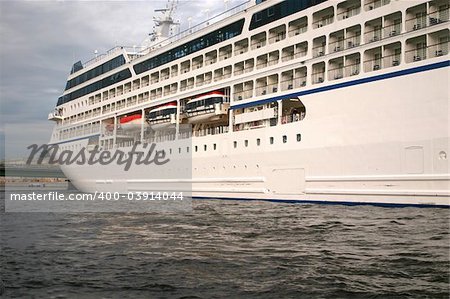 Ocean liner at St. Petersburg's port in the summer evening. Clouded skies and culm water.