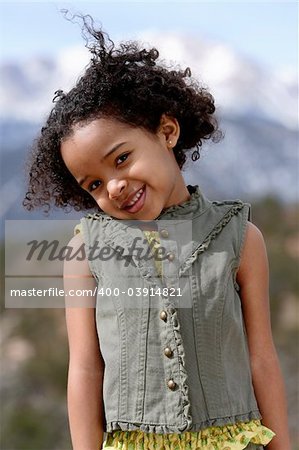 Cute little girl doing fashion photo shoot in a mountains