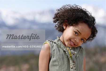 Cute little girl doing fashion photo shoot in a mountains