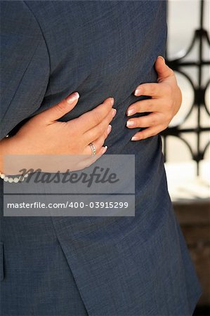 Hands of the bride hugs the groom