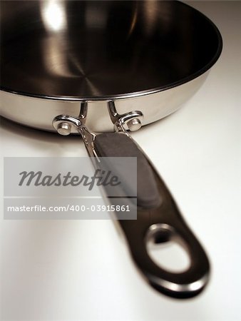 A stainless steel frying sitting with the handle facing out.