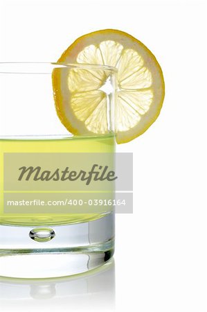 A glass of fresh lemon juice with a slice reflected on white background