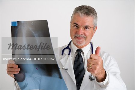 Doctor with a thumbs up after evaluating an x-ray,