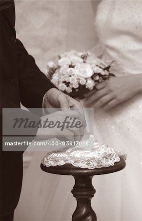 Hands of the groom and the bride during wedding ceremony