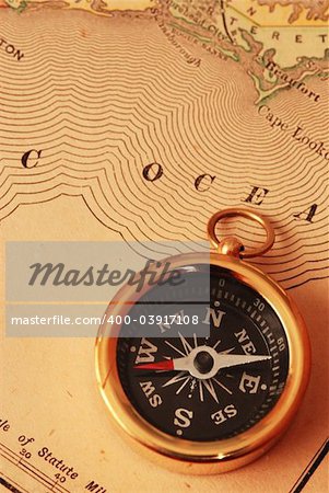 Antique brass compass over old USA map background