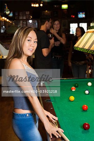 Portrait of young asian woman beside billiards table in pub.