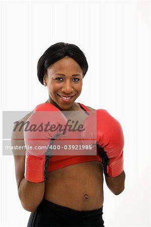 African American young adult woman wearing boxing goves smiling at viewer.