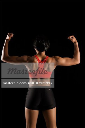 Back view of muscular African American woman with biceps flexed.