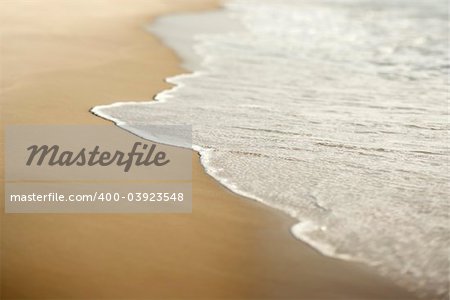 Image of sandy beach with waves.