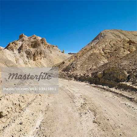 Dirt road through barren landscape in Death Valley National Park.