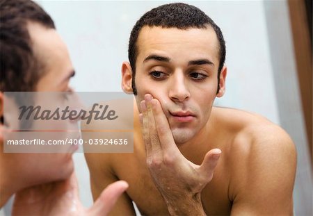 morning routine: a man looking at himself at the mirror
