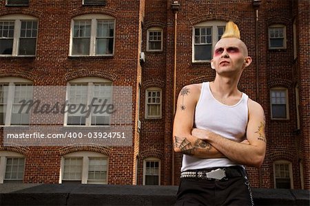 Portrait of a mid-adult Caucasian male punk  with building in background.
