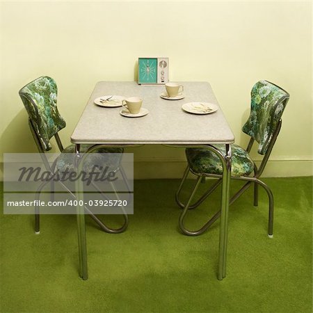 Retro 50's formica and chrome dinette set with green vinyl chairs.