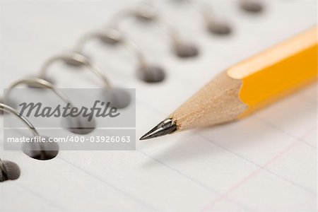 Close up of pencil on top of spiral bound notebook.