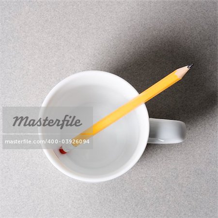 High angle view of a pencil in an empty white coffee cup.