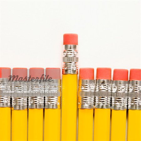 Even row of eraser ends of pencils with one raised higher than the rest.