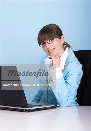 Satisfied businesswoman working with a laptop on a blue background