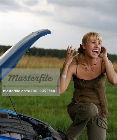 young blond woman with her broken car. The girl is sad