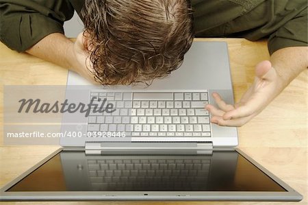 Frustrated businessman shows his frustration while working on his laptop.