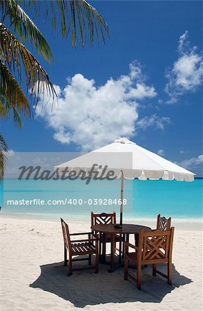 dining place with wooden chairs, table and white sun shade in a cafe on an maldivan island in the Indian Ocean