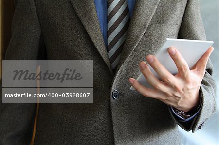 Smartly dressed business man holding a writing pad.