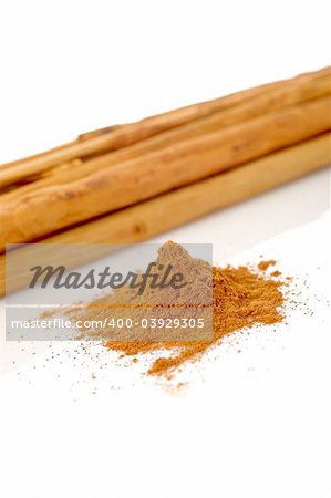 Sticks and powder of cinnamon reflected on the white background. Shallow DOF