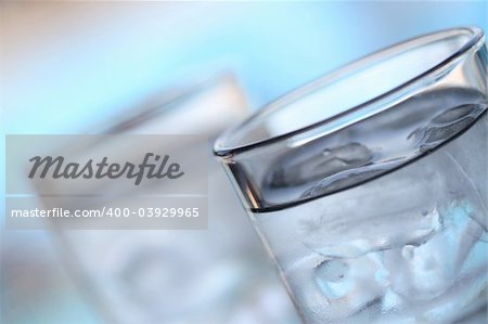 Macro photo of two glass of water and ice.