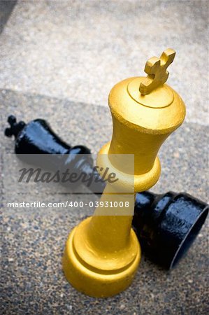 A black chess king piece checkmate by a gold chess piece
