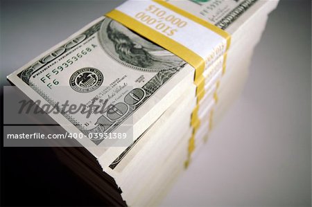 Stacks of Hundred Dollar Bills on a white background.