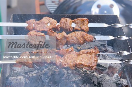 Appetizing grilled kebab on metal skewers outdoors at picnic
