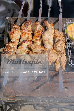 Appetizing shish kebab on metal skewers outdoors at picnic