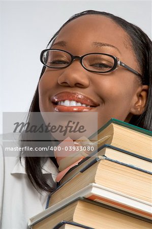 Female Student rests her head on stack of books