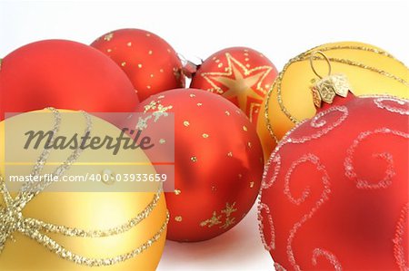 Closeup of red and yellow Christmas ornaments on white background