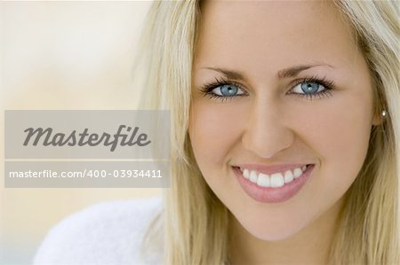 Close portrait of a beautiful young blue eyed blond woman wearing a bathrobe and bathed in soft natural light